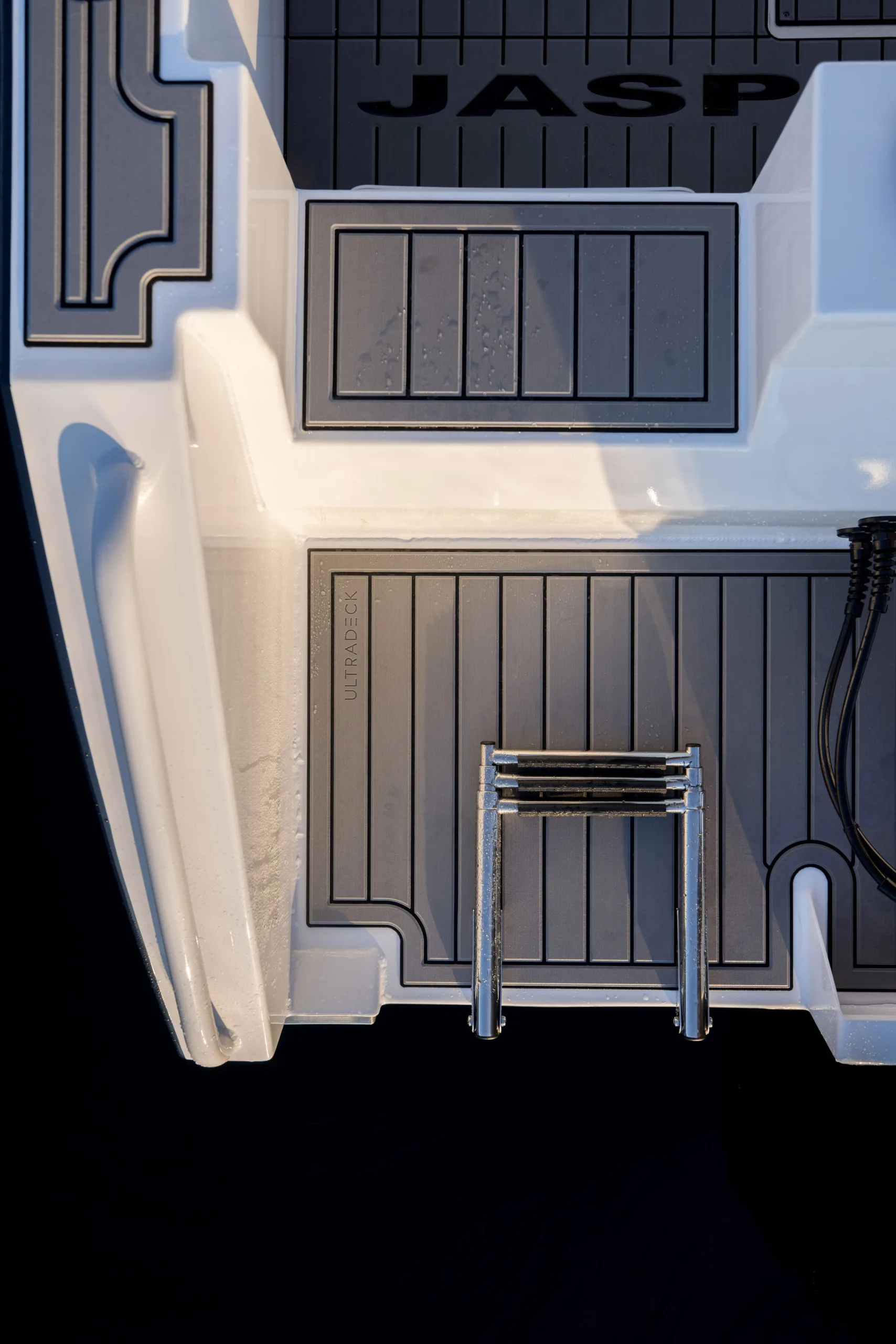 The back of a white boat out on the water showing the UltraDeck Marine Flooring up close.